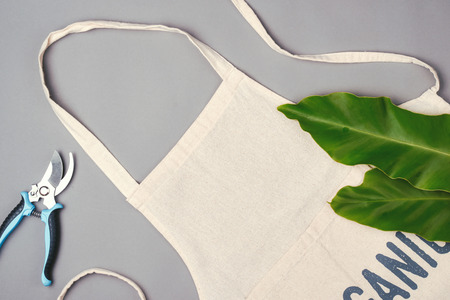 Apron with leaves and scissors on table. Top view.の写真素材