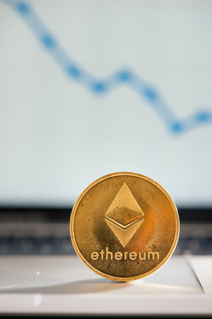 golden ethereum on notebook keyboard with increasing chartの写真素材