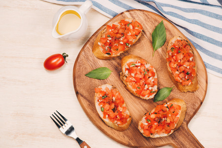 Simple italian appetizing bruschetta with tomato, on wooden tableの写真素材