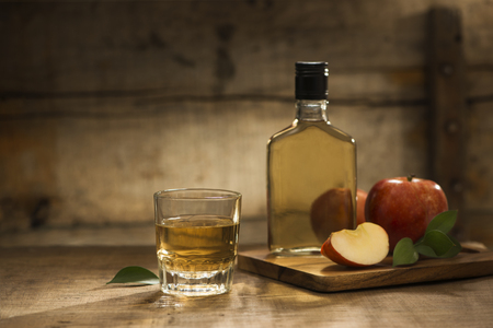 Bottle and glass of natural apple juice and sections of appleの写真素材