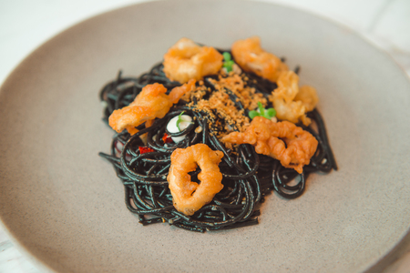 Black squid ink pasta is paired with scallops on pasta dishの写真素材