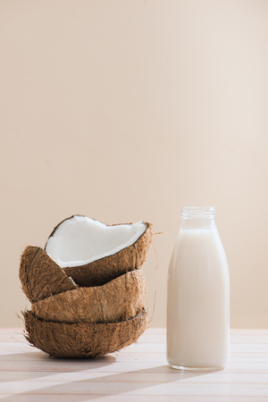 Coconut milk in bottle and glass on table with copy spaceの写真素材
