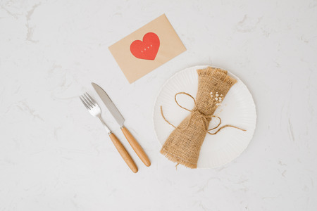 love dinner setting fork and spoon tie with red ribbon on plate on white background , love and...