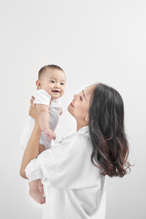 Happy loving family. Young smiling mother hugging laughing baby.の写真素材
