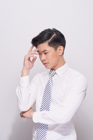 Young business man looking down isolated on white backgroundの写真素材