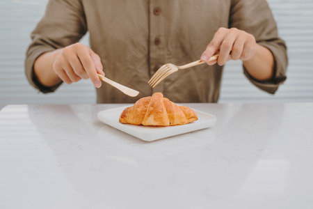 A man eating fresh croissant baked on Saturday morning