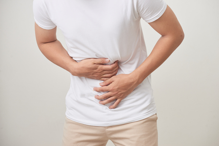 people, healthcare and health problem concept - unhappy man suffering from stomach ache over white backgroundの写真素材