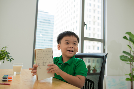 Head shot Portrait of happy asian cute child doing homework with smile face at home .の写真素材