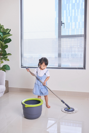 A little cute asian girl doing house cleaning with mopの写真素材
