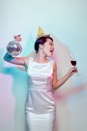 Party and holidays concept. Young asian woman  drinking cocktails and having funの写真素材
