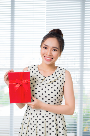 Young beautiful asian woman holding red gift boxの写真素材