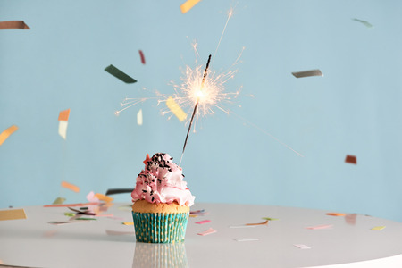 Single sparkler on cupcake blue walの写真素材