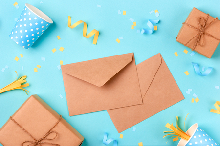 Celebration envelope, birthday party things and laptop on a yellow backgroundの写真素材