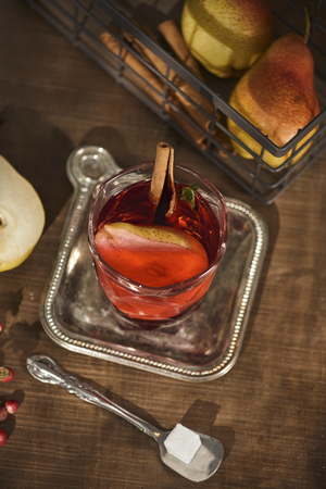 Glass of Cider pear cocktail or lemonade, cinnamon sticks, anise stars on wooden background.の写真素材