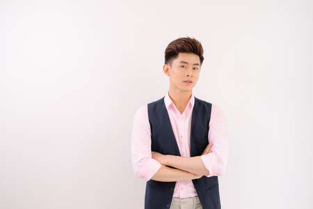 Handsome asian man stand and smile posing on gray backgroundの写真素材
