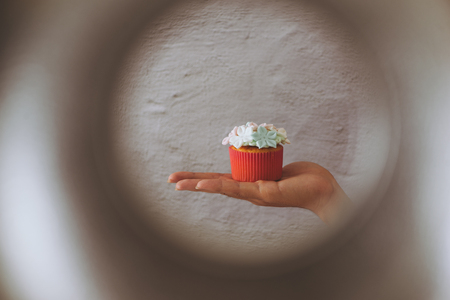 Valentine sweet love cupcake in hand on light backgroundの写真素材