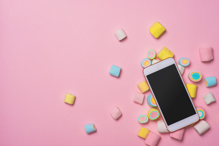 Marshmallows with smartphone, on pastel background, decoration for love and valentine day concept.の写真素材