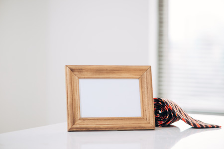 Father's day composition. Blank frame and tie with space for text on wooden table topの写真素材