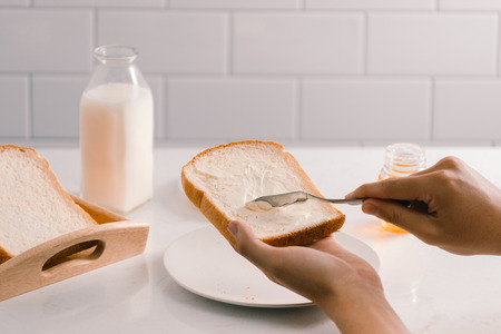 Man spreading butter on slice of bread, closeup