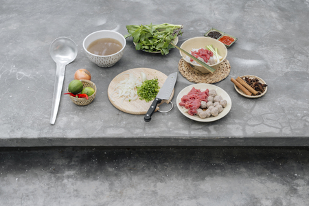 Traditional Vietnamese soup Pho bo with herbs, meat, rice noodles, broth. Pho bo in bowl with chopsticks, spoon. Space for text. Top view. Asian soup Pho bo on wooden table background. Vietnamese soupの写真素材