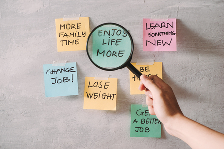 Group of New year Resolution Notes on pink, yellow, orange and green on wall written with message of diet, join gym, find love and be happyの写真素材