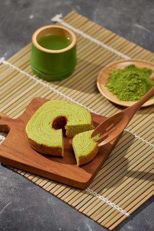 Matcha green tea latte in a cup and tea ceremony utensils with German cake. Copy spaceの写真素材