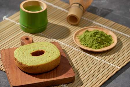 Matcha green tea latte in a cup and tea ceremony utensils with German cake. Copy spaceの写真素材