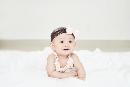 Baby girl smiling on the floor isolated on whiteの写真素材