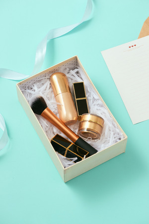 Make up gift box with serum, blush, brushes, cream and lipsticks indoorsの写真素材