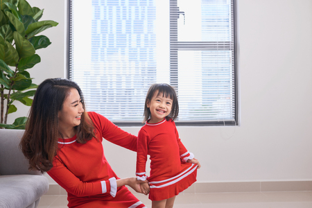 Happy young mother laughing with her little daughter in the morning. Having fun together. Joyful family time at home.の写真素材