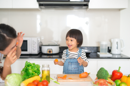 Mother with her daughter in the kitchen cooking togetherの写真素材