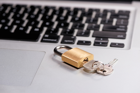Computer security and data protection concept. Laptop with an locked lock and key on it.の写真素材