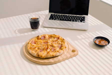 Tasty pizza on working table at office.の写真素材