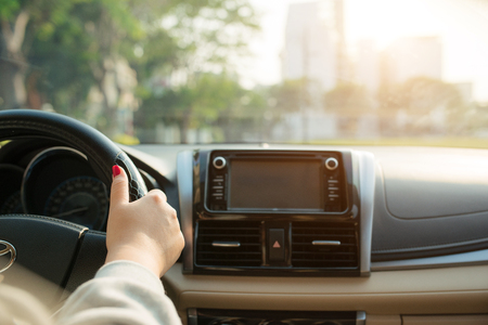 Asian female hands on the steering wheel of a car while driving with windshield and road. Black woman hands holding a steering wheel confidently. Hands on wheel - Woman driving car - Asiaの写真素材