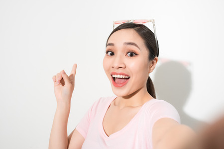 Young happy smile girl take selfie on white backgroundの写真素材