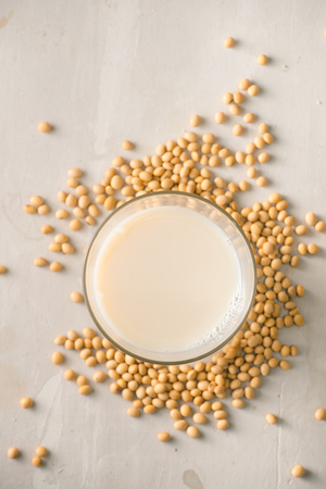 Soy milk or soya milk and soy beans on stone table.の写真素材