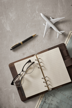 Empty white space in notebook where you can place your text or advertisement. Airplane, magnifying glasses and glasses on the map. Romantic travelの写真素材