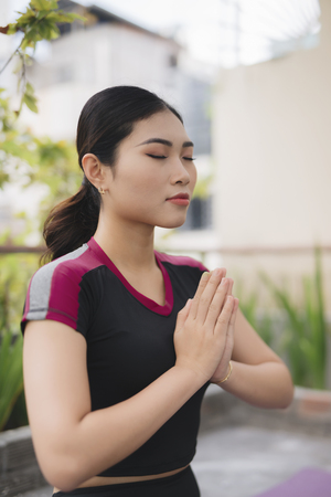 Beautiful woman doing yoga outdoors on a rooftop terraceの写真素材