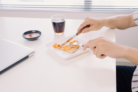 Eating tasty pizza on working table at office.の写真素材