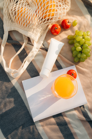 Fruit net bag with flip flop, sun cream on the plaidの写真素材