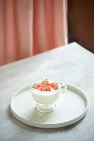 fresh organic yogurt with strawberries on tableの写真素材