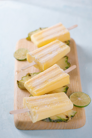 Pineapple ice cream on a marble paddle board. Top view over a blue wood background.の写真素材
