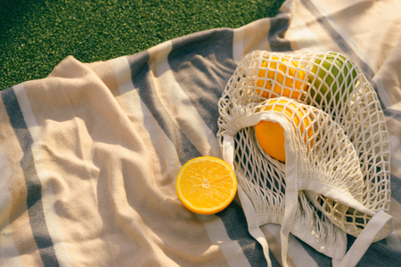 Fruit net bag on the plaid in the fieldの写真素材