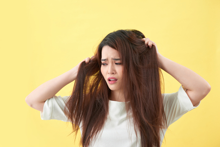 Woman holding damaged hair the hand and looking. Isolated portraitの写真素材