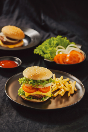 Homemade burger and cheese with fries and icy soft drinkの写真素材