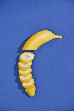 Bananas and slices isolated on a blue backgroundの写真素材
