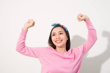 Attractive young woman relax and dance on copy space. Portrait of happy girl dancing your hands up on white backgroundの写真素材
