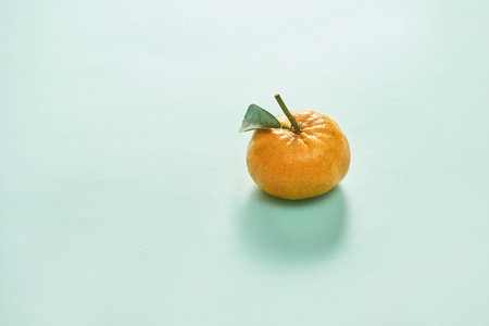 Tangerine or clementine with green leaf isolated on blue background - Imageの写真素材