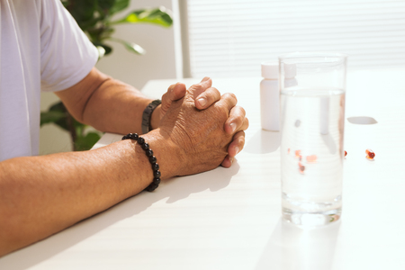 Mature asina man taking pill at homeの写真素材