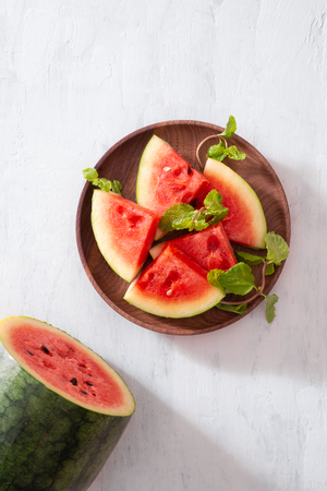 Cut slices of ripe juicy watermelon on wood plateの写真素材
